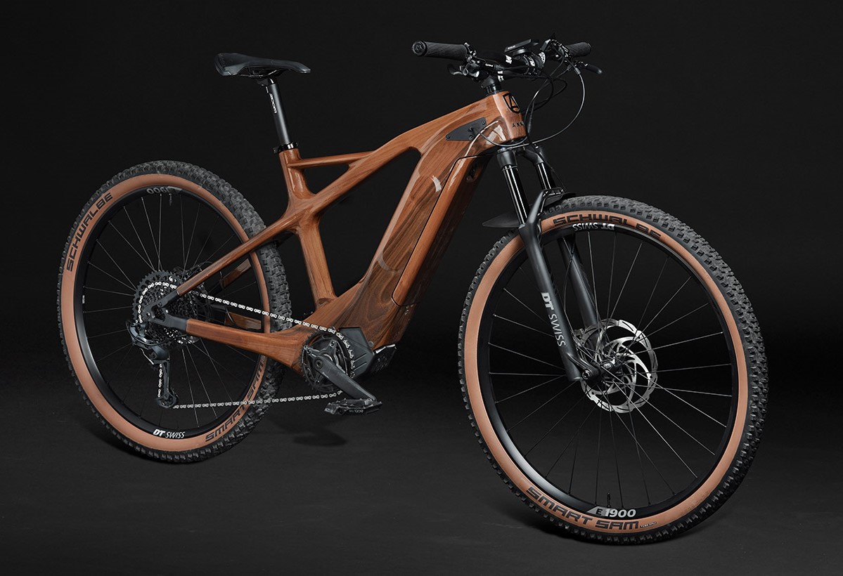 e-ANNUM wooden electric mountain bicycle against a dark background